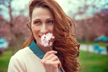 happy female smelling blossom