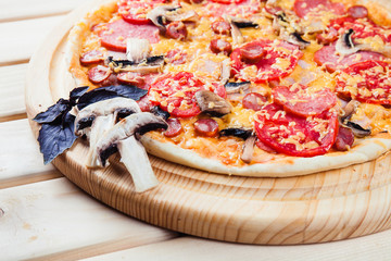 Mushroom pizza on the wooden background
