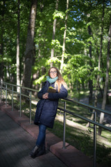 Happy girl reading a book at the railing.