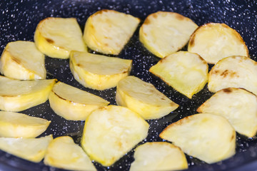 Large slices of potatoes are fried