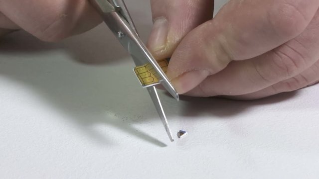Destroying old SIM card with scissors. Personal data destruction.