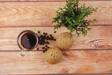 Morning breakfast concept with coffee,bun, post it notes on wooden background.