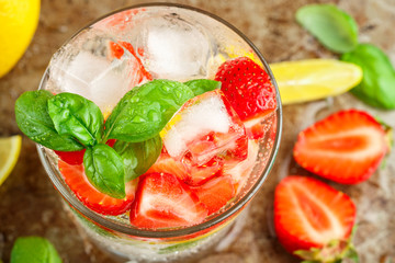 Summer a refreshing lemonade. Drink with lemon, strawberries, mint, Basil and ice. Detox. Mineral water. Selective focus