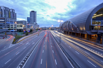 Fototapeta premium KUALA LUMPUR, 22 JANUARY 2017. light trails on highway at sundown time, long exposure, urban background with sun and dark sky. Blurred motion and noise effects.