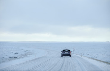 A car running on a road covered by snow in Iceland