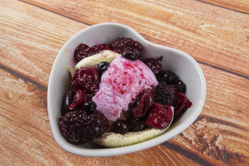 Ice cream scoops with blueberry,chery on wooden table.