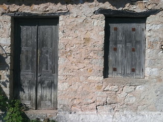 old stone building with wooden door and shutter