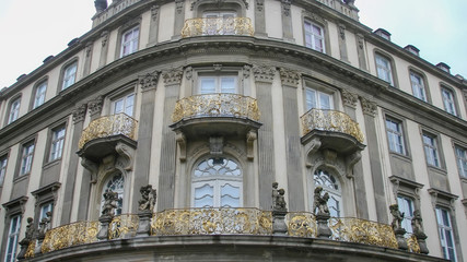 Fototapeta na wymiar Corner of a building with gold coloured balconies