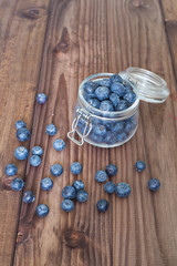 Blueberries in a jar on a wooden table.
