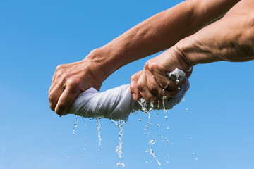 Hands squeeze wet cloth.