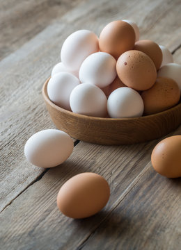Wooden bowl of raw chicken eggs