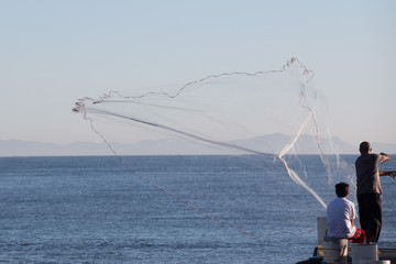 A fisherman using a fishing net