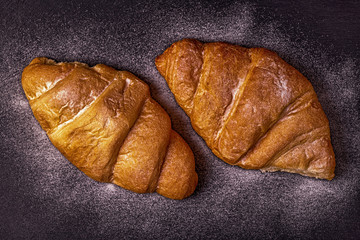 Fresh croissant on dark background.