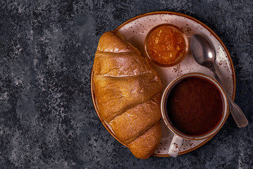 Fresh croissant on dark background.