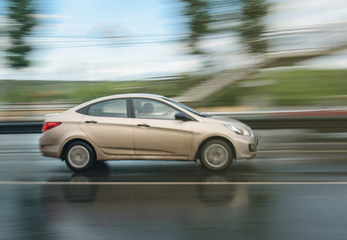 Obraz na płótnie Canvas white car driven on rainy roads with blur background