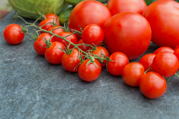 red tomatoes on a branch and board