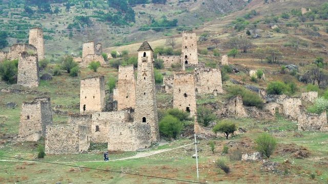 Sight Towers and Defensive Towers of the North Caucasus. Historical monumental medieval buildings in the mountains. People walking near historical sights in Ingushetia