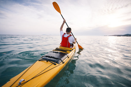 Rear view of man paddling sea kayak