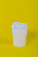 A coffee cup take away on yellow background