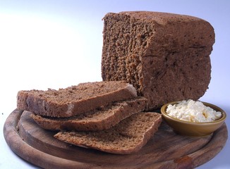 Partly Sliced Black Brown Bread on Cutting Pad with Garlic Souse Toum 