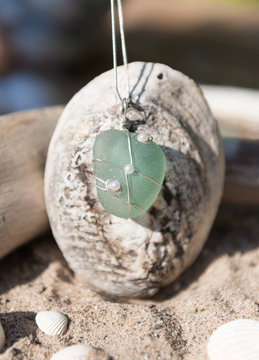 Unique handmade aqua blue sea glass jewellery, with a silver chain in a sea shell.