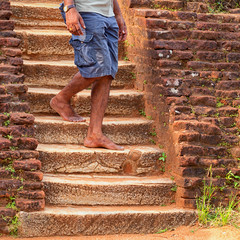 Local man walks down old stone steps. Sri Lanka