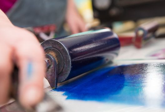 an acrylic paint roller for mono printing and screen printing, rolling paint ready for mono printing.