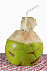Fresh coconut on chintz with tube on white background