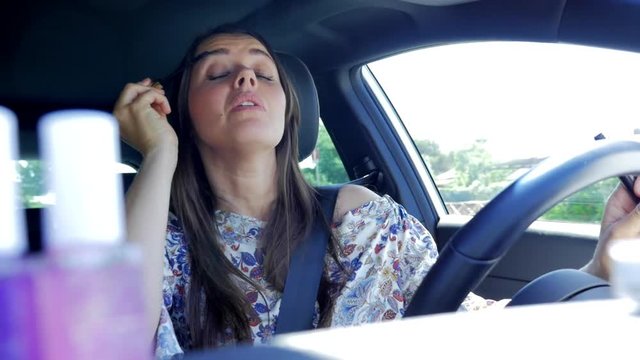 Woman distracted while driving car by putting eyeliner makeup dangerous