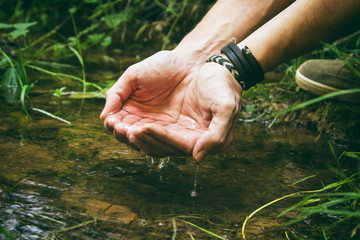 Manos de hombre con agua fresca de manantial 