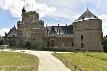Fototapeta premium L'imposante muraille du château de Gaasbeek émergeant des chemins de son parc 