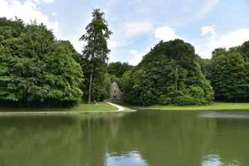 Fototapeta na wymiar L'un des étangs avec la chapelle St-Gertrude au fond en plein bois au domaine du château de Gaasbeek près de Bruxelles 