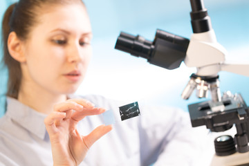 Doctor woman working  a microscope. Female scientist looking through a microscope in lab. Student...