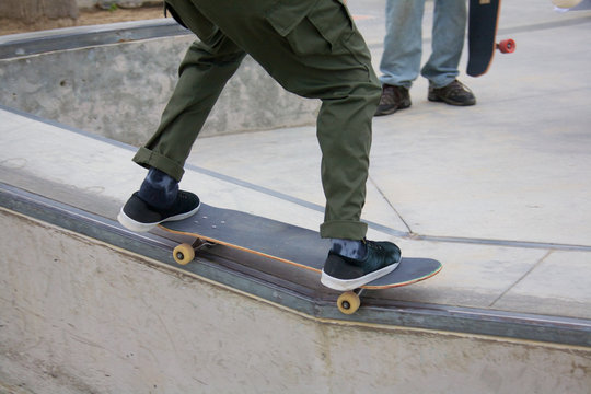 Male doing rail grind while skateboarding at Venice Skate Park in Venice Beach California.