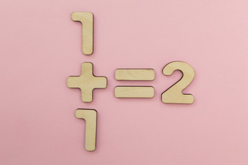 One plus one equals two. Pink background.