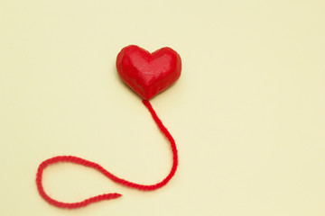 Red heart balloon on a yellow background