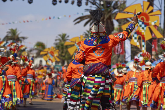 Tinkus dance group in colourful costumes performing a traditional ritual dance as part of the Carnaval Andino con la Fuerza del Sol in Arica, Chile.