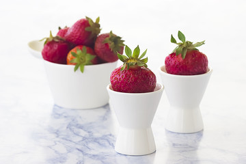 Bright ripe strawberry on a light marble background.