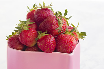 Bright ripe strawberry on a light background. Delicious summer treat.