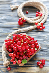 Red currant in a wooden bowl.