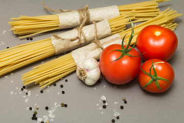 A recipe for a classic pasta on a gray background. Spaghetti and vegetables.
