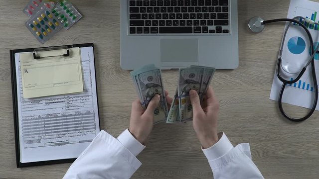 General practitioner counting cash earned on treatment of private patient, money