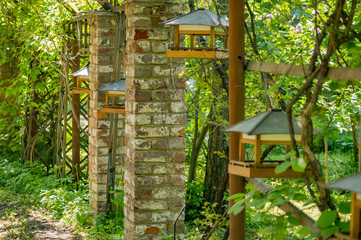 View of old brick columns in a park. Bird feeders in the city park.