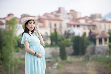 Fototapeta premium Pregnant Woman Stand in front of village