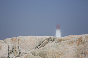 Fototapeta na wymiar Peggy's Cove on a foggy day with the lighthouse in the distance 