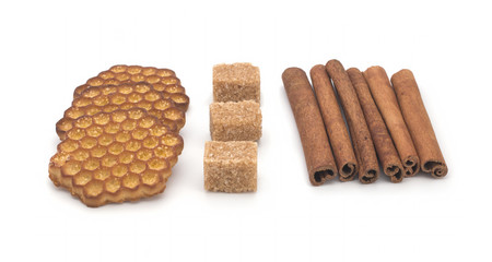 Biscuits, cane sugar, cinnamon sticks on white background