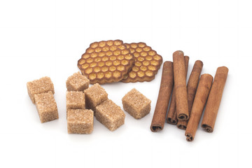 Biscuits, cane sugar, cinnamon sticks on white background