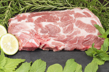 Fresh pork chop, a sprig of rosemary, mint leaves and half a lemon