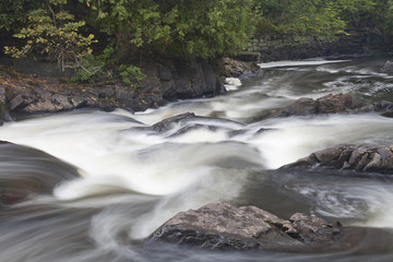 Fototapeta premium Waterfall and current movement in a river in the woods.