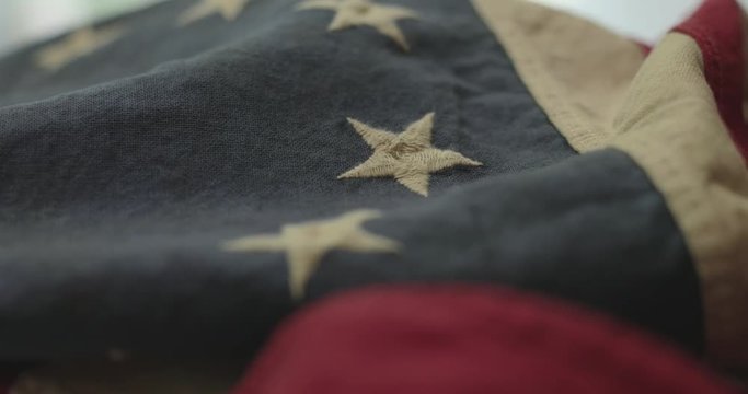 American flag detail with red and white stripes with field of blue and circle of 13 stars, the flag designed by Betsy Ross during the American Revolution. Shot in cinematic 4K.